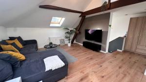 a living room with a blue couch and a flat screen tv at Modernes City-Apartment in Mönchengladbach in Mönchengladbach