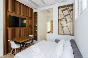 1 dormitorio con cama, mesa y TV en Central modern flat btw Syntagma and Monastiraki, en Atenas