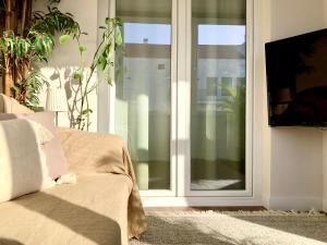 een woonkamer met een glazen schuifdeur bij Apartamento Torres Vedras Centro in Torres Vedras