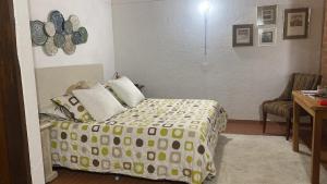 1 dormitorio con 1 cama con edredón amarillo y blanco en FINCA VERDI, en Girardota
