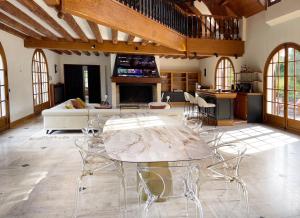 ein großes Wohnzimmer mit einem Tisch und Stühlen in der Unterkunft Belle demeure de 500m2 avec 6 chambres in Auffreville-Brasseuil