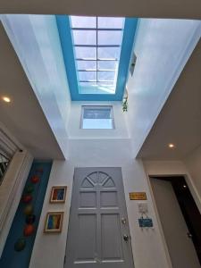 a hallway with a door and a skylight in a house at MAGAYON BLUE HOUSE IN THE HEART OF LEGAZPI in Legazpi