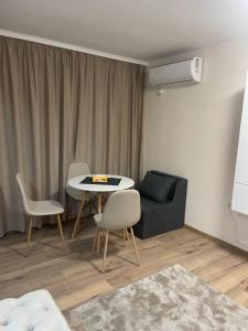 a living room with a table and chairs and a couch at Teddy Apartment in Veliko Tŭrnovo
