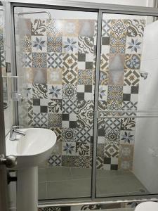 uma casa de banho com um lavatório e um chuveiro com azulejos. em COOL HOUSE 24Horas em Arauca