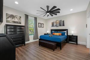 a bedroom with a blue bed and a black dresser at Luxury Retreat Hot Tub for 8 in Stylish Bungalow in Tampa