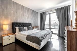 a bedroom with a bed and a large window at Tampa Gardens Zen Apartment - Adults Only in Braşov