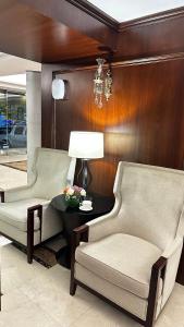 Laten Suites Prince Sultan في جدة: غرفة معيشة مع كرسيين وطاولة