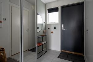 einen Flur mit einer schwarzen Tür und einem Spiegel in der Unterkunft Viihtyisä yksiö, oma parkkipaikka, wifi, Aino Areena 300m in Järvenpää