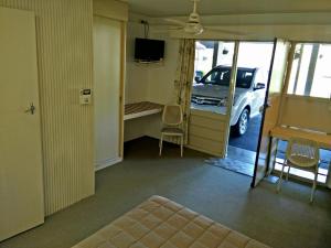 una habitación con un coche aparcado en un aparcamiento en Cairns Motor Inn, en Cairns