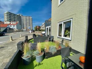 una fila de macetas al lado de un edificio en Glücklich am Meer Suite Deluxe mit Wellnesszugang en Egmond aan Zee