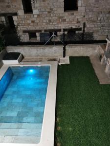 a swimming pool in a yard with green grass at LOS MIRLOS in Navaluenga