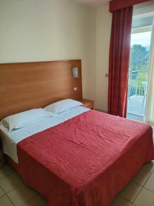 a bedroom with a large bed with a red blanket at Casa Del Mar in Roseto degli Abruzzi