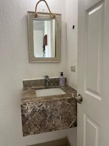 een badkamer met een marmeren wastafel en een spiegel bij Beautiful family vacation home in Nuevo Vallarta in Nuevo Vallarta 