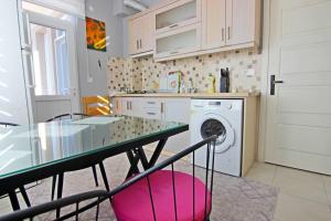 a kitchen with a table and a washing machine at Ozkan Apartment - Fethiye Center Fully Furnished 50Mbps Wifi Netflix in Fethiye
