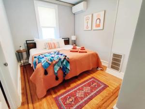 a bedroom with a large bed with a orange blanket at Cozy 1BDR In Center City Philly Hosted By StayRafa in Philadelphia