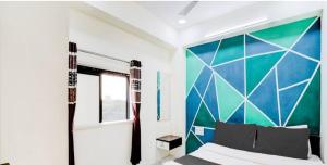 ein Schlafzimmer mit einem Bett mit einer farbenfrohen Wand in der Unterkunft HOTEL GREENITY in Ahmedabad