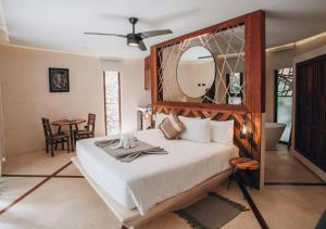 a bedroom with a bed with a mirror and a table at Kan Tulum in Tulum