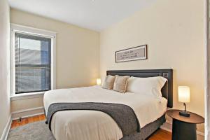 a bedroom with a large bed and a window at Cozy and Inviting Two-Bedroom Apartment - Sunnyside 3F in Chicago