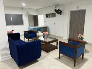 COOL HOUSE 24Horas في أراوكا: غرفة معيشة مع أريكة زرقاء وطاولة