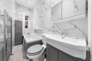 a white bathroom with a toilet and a sink at SERCASA - Woodside Park - North Finchley in Whetstone