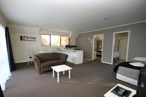 a living room with a couch and a table at Champers Motor Inn in Lower Hutt