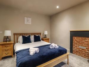 Un pat sau paturi într-o cameră la Cononley Cottage