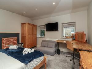 Televízia a/alebo spoločenská miestnosť v ubytovaní Cononley Cottage