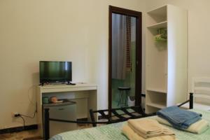 a bedroom with a bed and a tv and a room at Alghero Budget Automated check in in Alghero