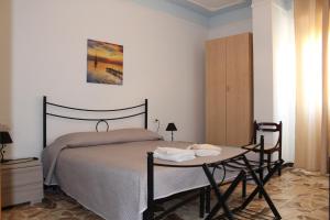 1 dormitorio con cama y mesa pequeña en Alghero Budget Automated check in, en Alghero