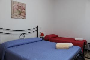 una camera con un letto blu e una sedia rossa di Alghero Budget Automated check in ad Alghero