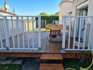 una terraza de madera con una mesa y una valla en Appartement indépendant dans villa accessible PMR, en Saint-Chamond