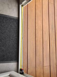 una puerta de madera con una cinta amarilla de medida en Appartement indépendant dans villa accessible PMR, en Saint-Chamond