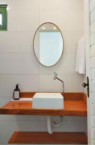 a bathroom with a white sink and a mirror at Pousada Fenícia in Japaratinga