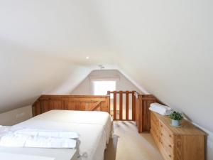a bedroom with a white bed and a window at Plas Bach in Rhoscolyn