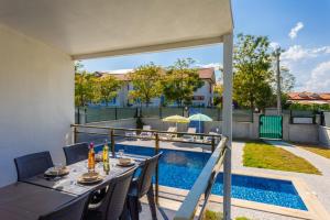 a patio with a table and chairs and a swimming pool at Villa Sasha 3 in Ortaca