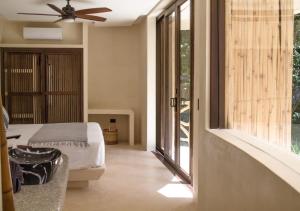 ein Schlafzimmer mit einem Bett und einem großen Fenster in der Unterkunft Kan Tulum in Tulum