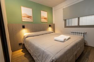 een slaapkamer met een bed met twee handdoeken erop bij M383 Hotel Bariloche in Bariloche