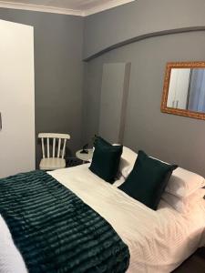 une chambre avec un grand lit avec une couverture verte dans l'établissement Self Catering Unit, à Hallack Rock