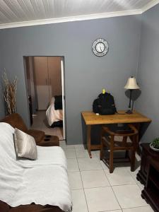 Cette chambre comprend un lit, un bureau et une horloge. dans l'établissement Self Catering Unit, à Hallack Rock 3 autres photos