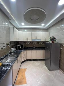 duża kuchnia ze zlewem i lodówką w obiekcie APPART HOTEL OUED EDDAHAB w mieście Chunajfira