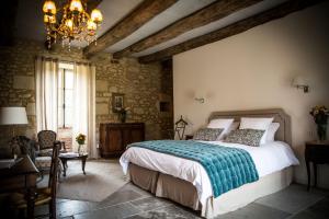 a bedroom with a bed and a chandelier at Les Cieux de Saint-Félix, Maison d'Hôtes & SPA in Saint-Félix-de-Villadeix