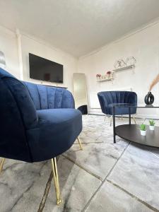 sala de estar con sofá azul y mesa en Entire 3 Bedroom Luxury Apartment in London with Private Balcony en Londres
