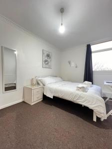 Un dormitorio con una cama grande y una ventana en Entire 3 Bedroom Luxury Apartment in London with Private Balcony en Londres