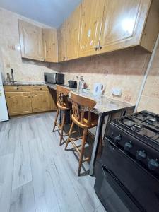 cocina con armarios de madera y encimera con fogones en Entire 3 Bedroom Luxury Apartment in London with Private Balcony en Londres