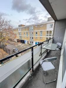 a balcony with a table and a chair on it at Entire 3 Bedroom Luxury Apartment in London with Private Balcony in London