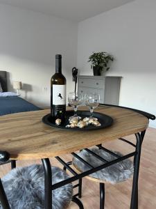 butelkę wina i dwa kieliszki wina na stole w obiekcie Apartmán Gabi w Łuczeńcu
