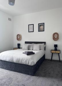 a bedroom with a large bed with two tables at Cosy Home in Manchester in Manchester