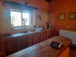 cocina con mesa de madera y ventana en Casas el Alamillo- el Castañero, en Galaroza