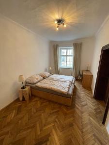 a bedroom with a bed on a wooden floor at Altstadt Apartment in Steyr