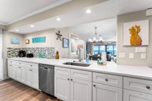 a kitchen with white cabinets and a sink at Fanta-Sea 55 in Siesta Key